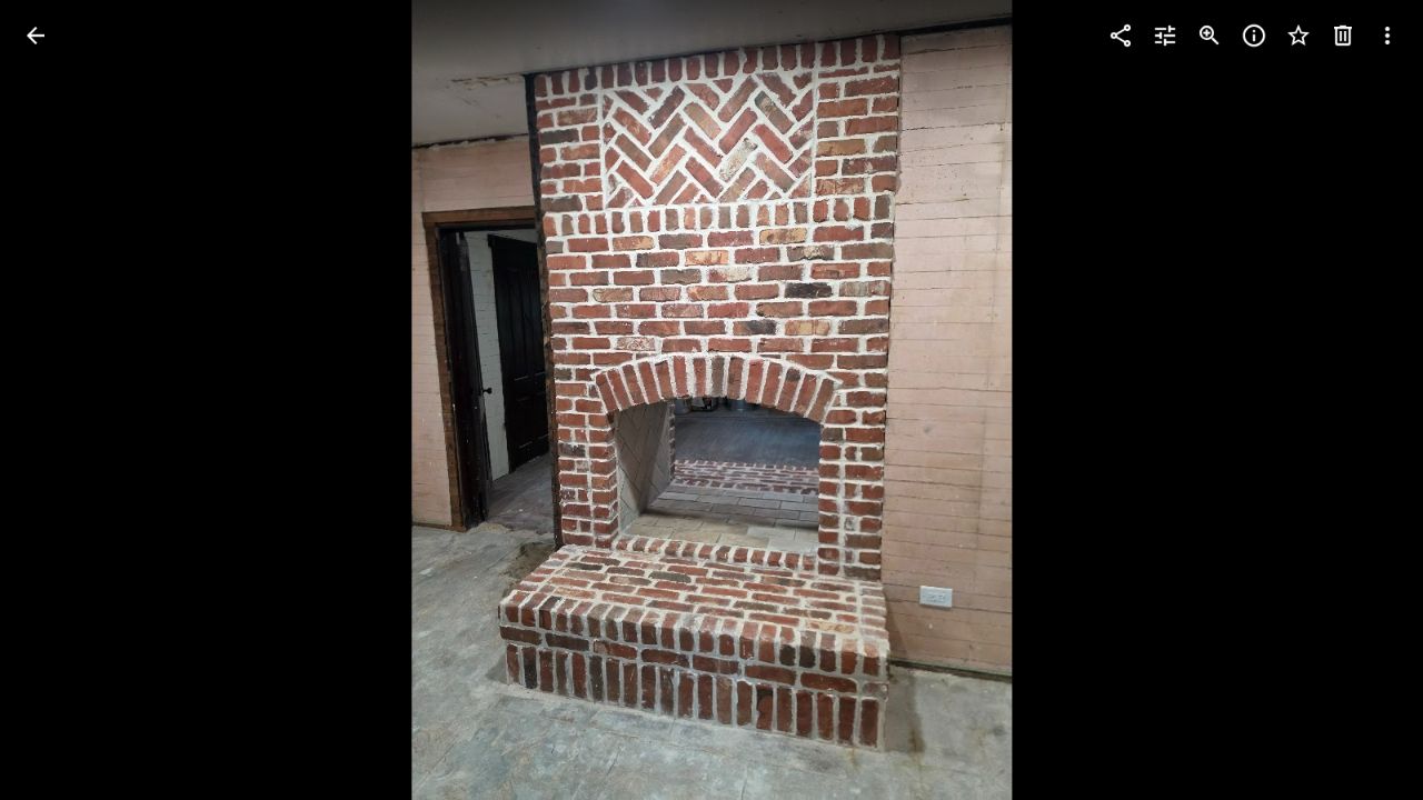 Detail of the brick hearth, arched firebox and patterned masonry on our custom fireplace project